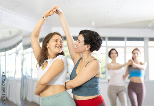 Couple young and adult woman rehearsing pair dance in studio