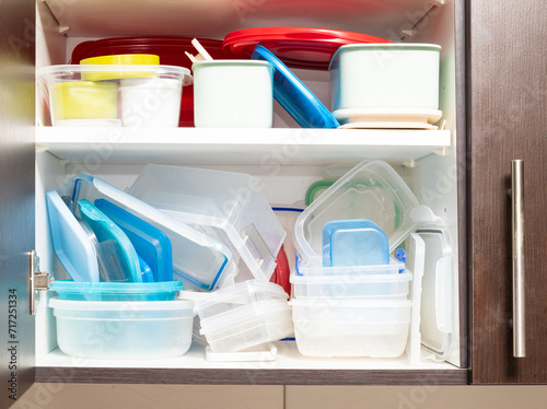 Canvas Print kitchen cabinet full of plastic food containers arranged in a haphazard manner