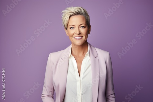 Portrait of a beautiful businesswoman smiling at the camera against purple background