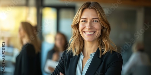 Portrait of a smiling businesswoman in a suit with her team in the office backdrop, team leader photo