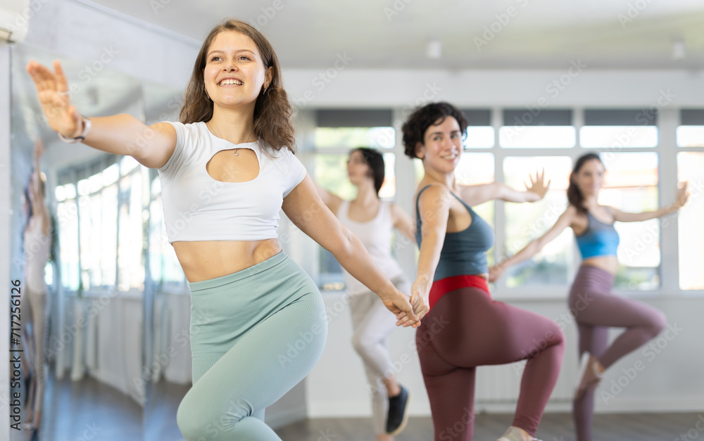 Fototapeta premium Sporty young woman dancing modern dance at class with his friends