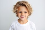 Portrait of a cute little boy with blond hair over grey background