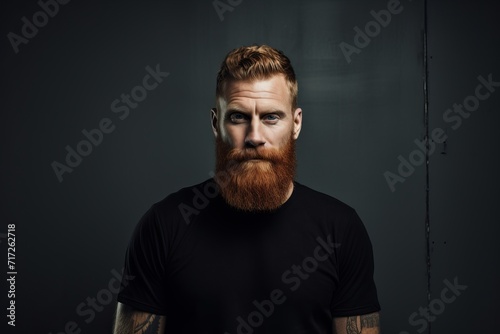 Portrait of a red-bearded brutal man in a black T-shirt.