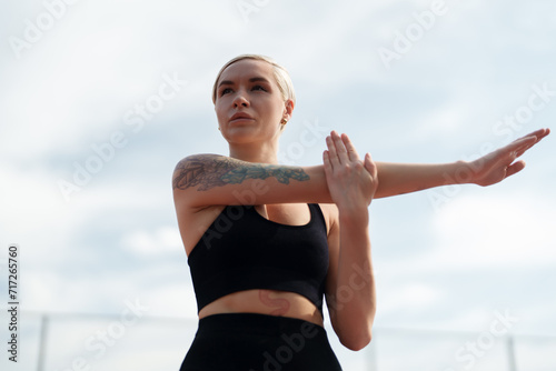 Картината върху платно Fitness enthusiast performs arm stretches, focusing on her pre-workout routine a