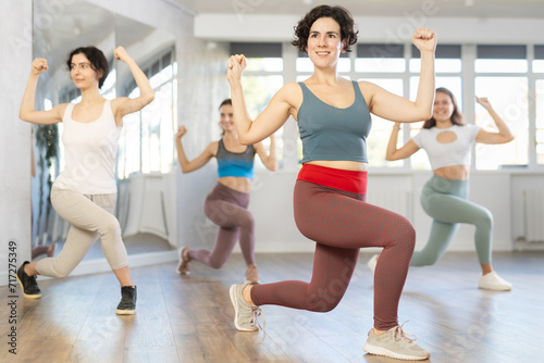 Active females exercising dance moves in a modern dance studio