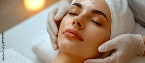 Cosmetic treatment for rejuvenating the face involving exfoliation  hydration  and a massage in a beauty spa salon with a model and a doctor.