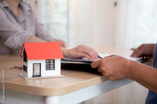 Closeup hands signing agreement document about buying home together at home, close-up hands of agent real estate giving document to elderly couple signature on contract with ownership residential.