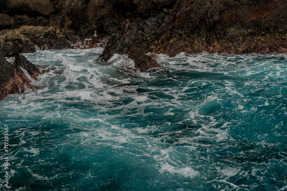 Waves breaking on the rocky shore of the island of Madeira