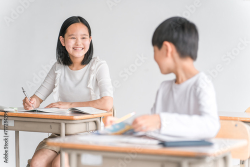 学校の教室で楽しく勉強する笑顔の女子小学生（塾・夏期講習） 