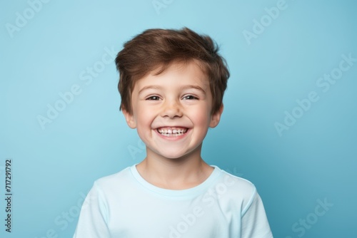 Portrait of a smiling little boy on a blue background. Close-up.