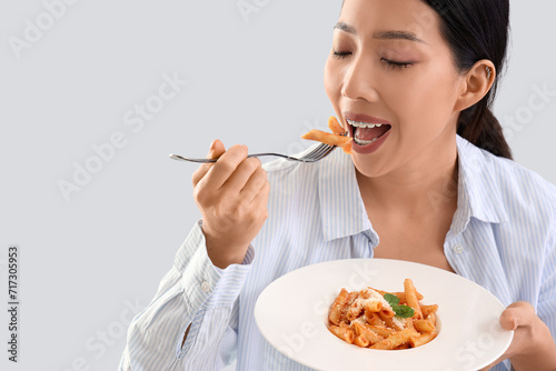 Young Asian woman eating ta...