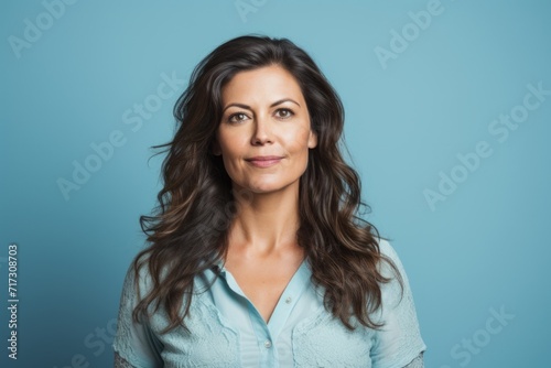 Portrait of a happy young businesswoman looking at camera over blue background