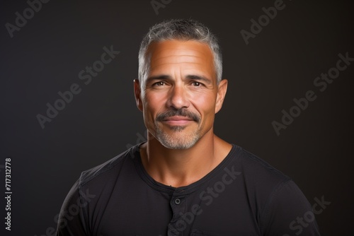 Portrait of a handsome middle-aged man over dark background. © Igor