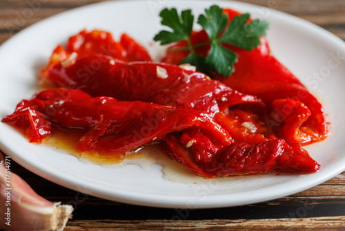 Peeled peppers, salad from grill baked marinated vegetable pepper, grilled fresh, portion on plate, ready to eat meal snack on the table, close up, food background, rustic