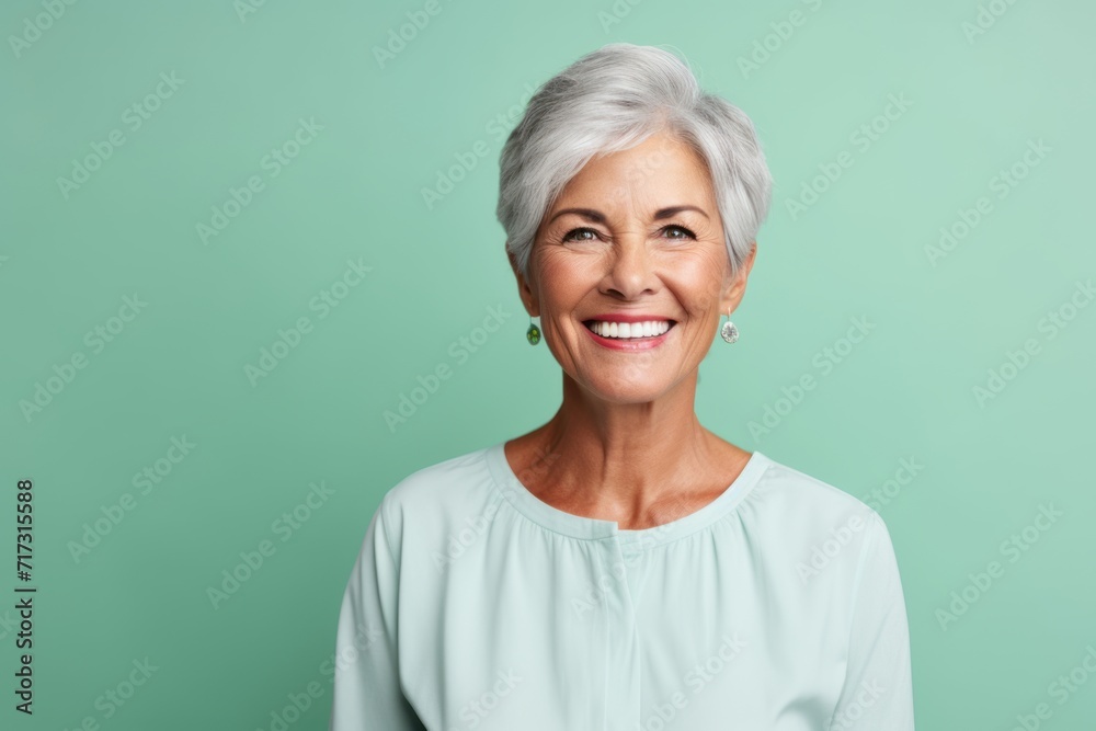 Portrait of a happy senior woman smiling at the camera over green background Portrait of a happy senior woman smiling at the camera over green background