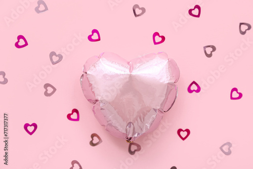 Composition with heart shaped foil balloon and confetti on pink background. Valentine's Day celebration