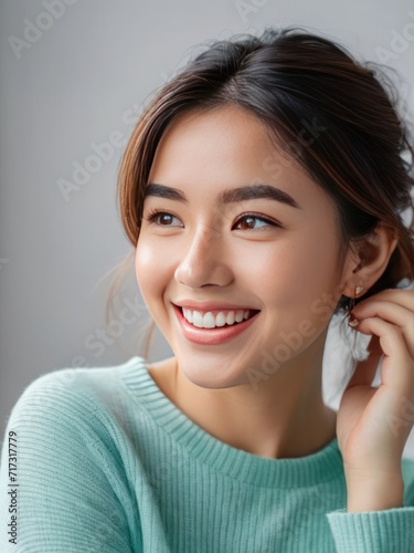Attractive and confident smiling young Asian woman close up portrait