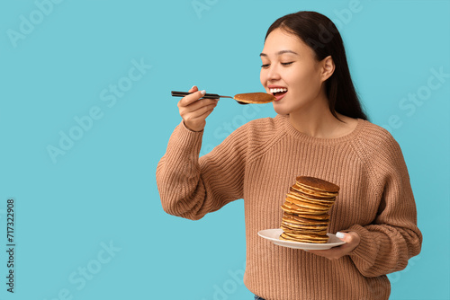 Young Asian woman eating ta...