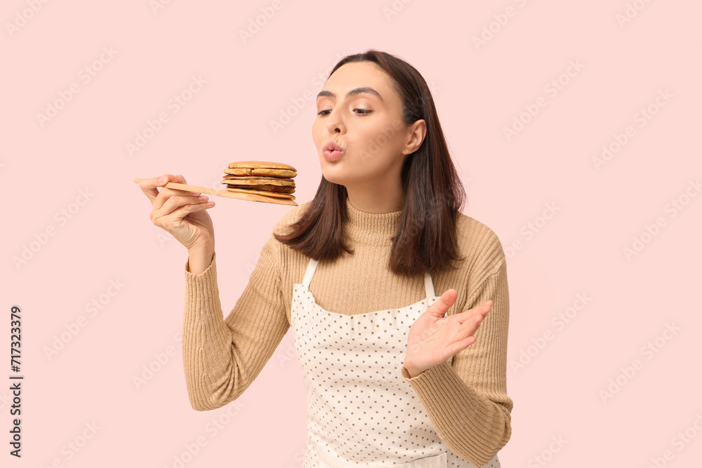 Beautiful young woman with tasty pancakes on pink background Beautiful young woman with tasty pancakes on pink background