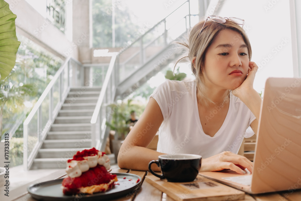 Serious and unpleasant face of asian woman work and solving problem with laptop.