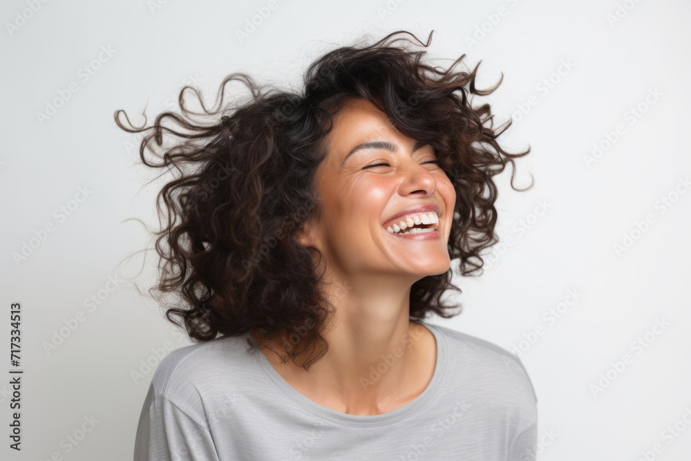 Portrait of a beautiful young woman laughing with her hair flying in the air Portrait of a beautiful young woman laughing with her hair flying in the air