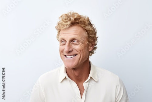 Portrait of a happy senior man smiling against a white background.