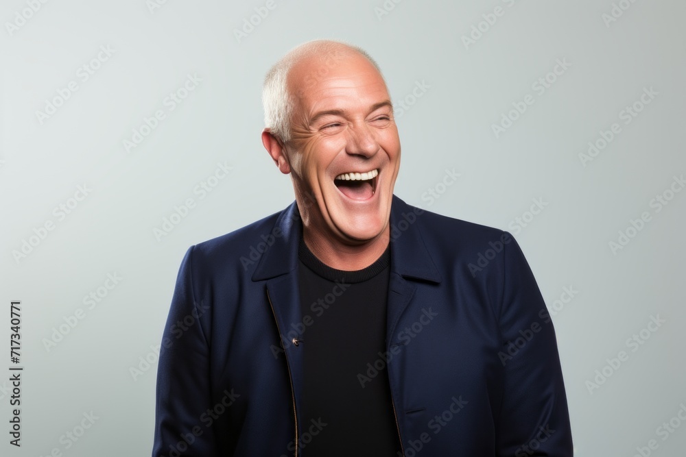 Portrait of a happy senior man laughing on grey studio background. Portrait of a happy senior man laughing on grey studio background.
