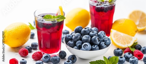 Fresh blueberry lemonade and bowl of berries on white background