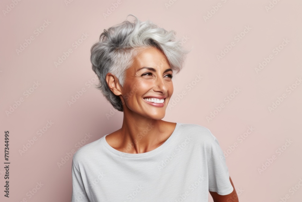 Happy smiling senior woman with grey hair and white t-shirt on pink background Happy smiling senior woman with grey hair and white t-shirt on pink background