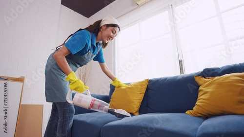Asian young beautiful woman cleaning indoors in living room at home.  photo
