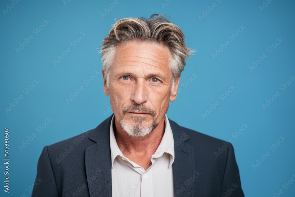 Portrait of a handsome senior man with grey hair and beard. Blue background. Portrait of a handsome senior man with grey hair and beard. Blue background.