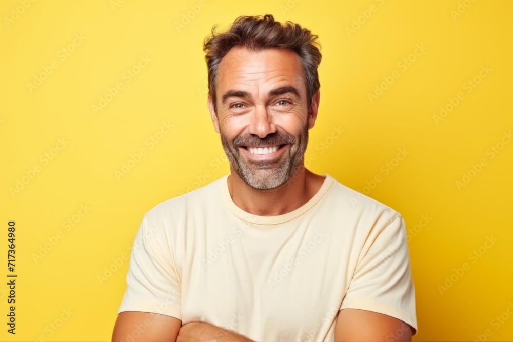 Portrait of a happy middle-aged man over yellow background. Portrait of a happy middle-aged man over yellow background.