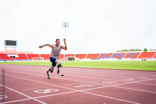 Asian para-athletes disabled with prosthetic blades running at stadium. 