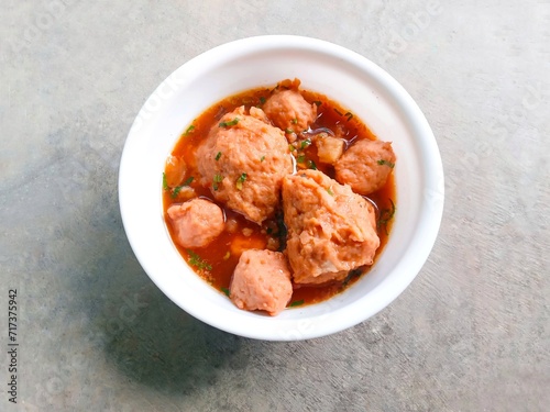 bakso, meatballs, traditional Indonesian food. Meatball soup with crackers. meatballs stuffed with quail eggs without noodles or vermicelli served in a bowl on a gray background.