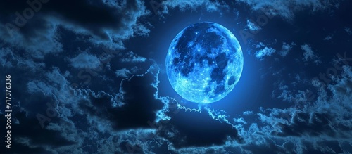 Dark sky with a full, blue moon.