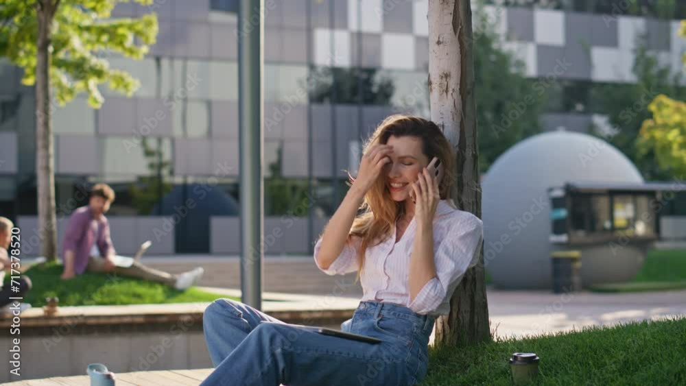 Smiling girl communicating smartphone with friend in park. Pretty woman resting Smiling girl communicating smartphone with friend in park. Pretty woman resting