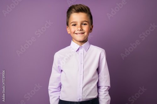 Portrait of a smiling little boy in a shirt and tie on a purple background. photo
