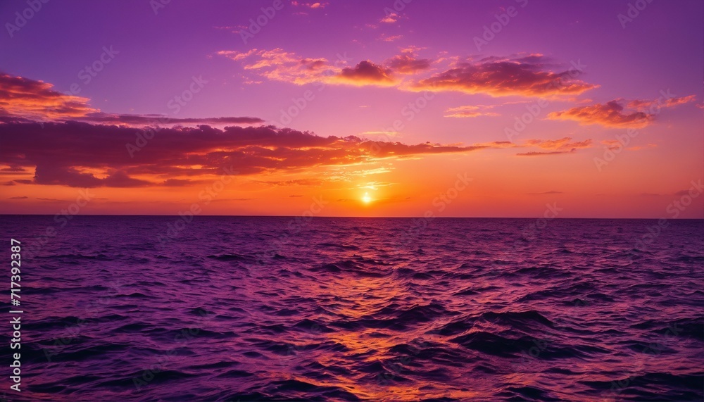 Sunset over the ocean viewed from the rear of a boat with waves in the foreground