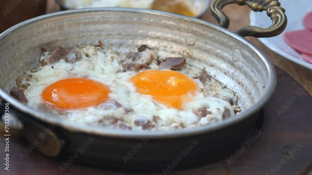 Turkish scrambled eggs with roasted meat in copper pan Turkish scrambled eggs with roasted meat in copper pan