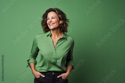 Portrait of a smiling woman in green shirt against a green background
