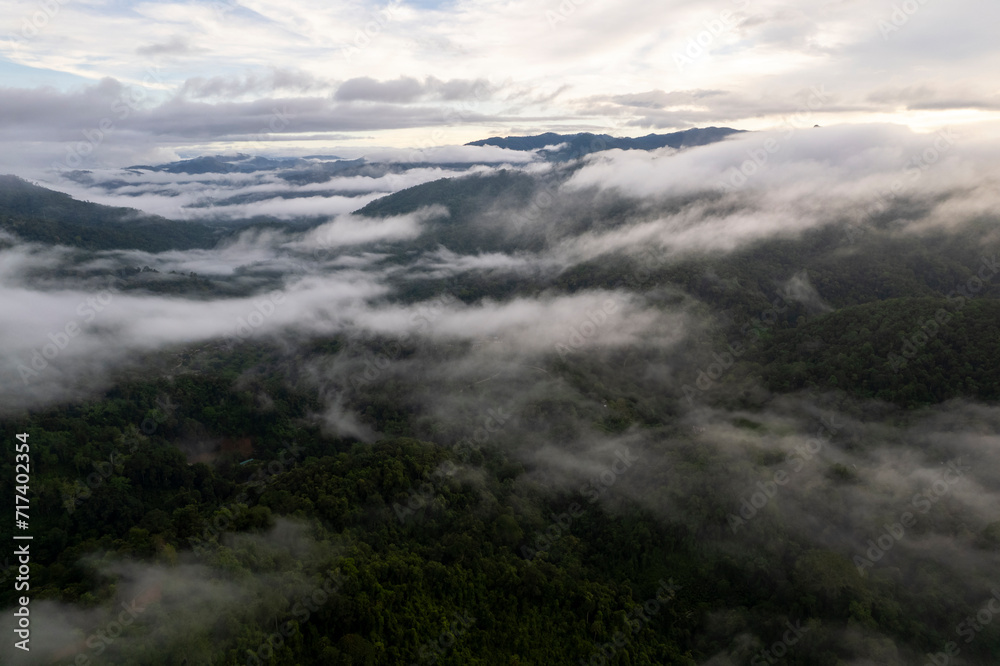 Fototapeta premium Top view Landscape of Morning Mist with Mountain Layer at north of Thailand. mountain ridge and clouds in rural jungle bush forest