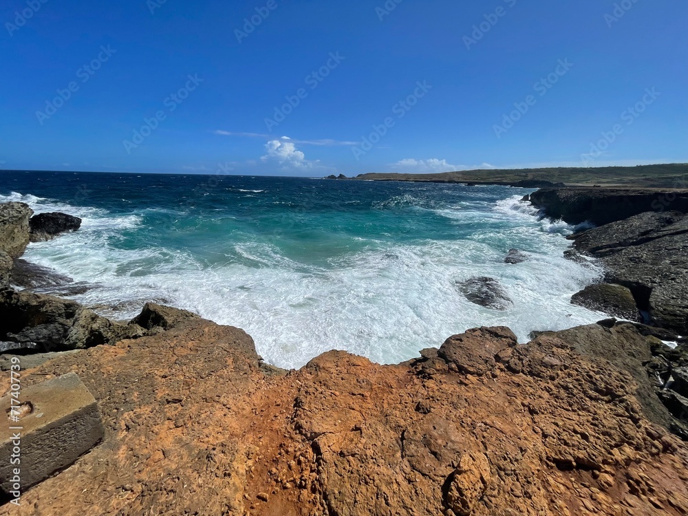 Rugged coastline of Aruba waves splashing on rocks Rugged coastline of Aruba waves splashing on rocks