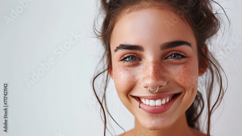 A woman with a septum piercing and freckles beams with a warm, inviting smile is AI Generative. photo