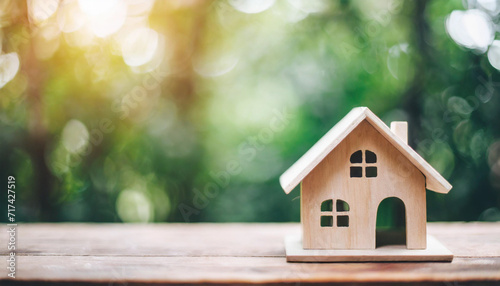 Wooden house model, symbolizing dreams, depicts a happy couple realizing home ownership aspirations, embodying affordability and family joy