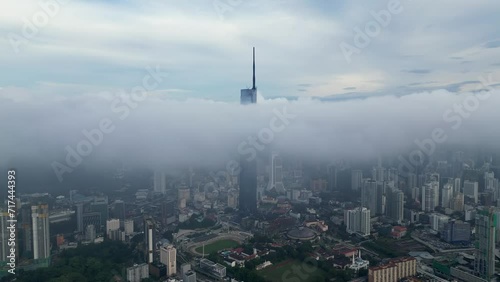Aerial shot of low clouds revealing an urban skyline Warisan Merdeka PNB118 at Kuala Lumpur photo