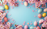 Easter eggs and cherry blossoms on pastel blue background with copy space.