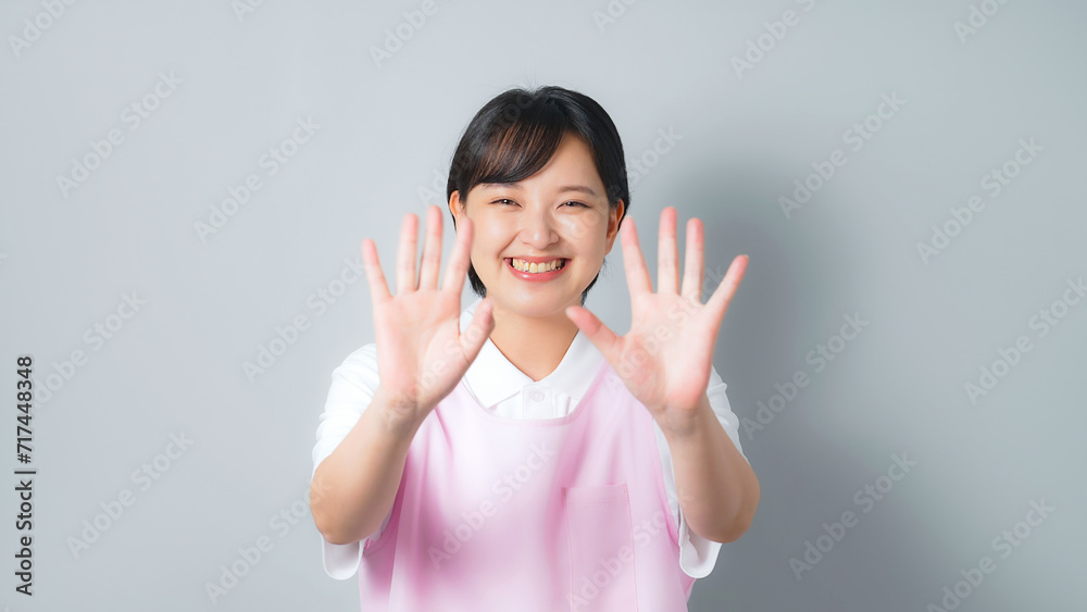 手を振るエプロンをつけた女性 保育士 介護士 手を振るエプロンをつけた女性 保育士 介護士