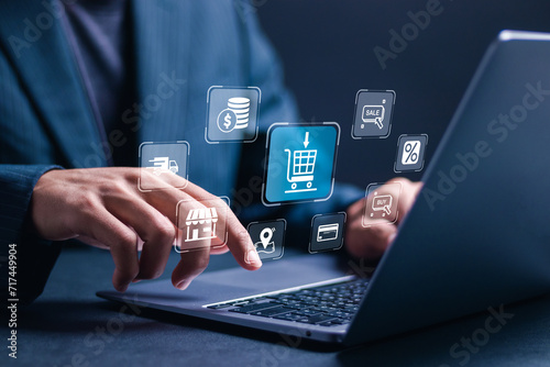 Online Shopping concept. Businessman use laptop with virtual screen of online shopping icon. Explore a seamless online shopping service with convenient home delivery options. photo