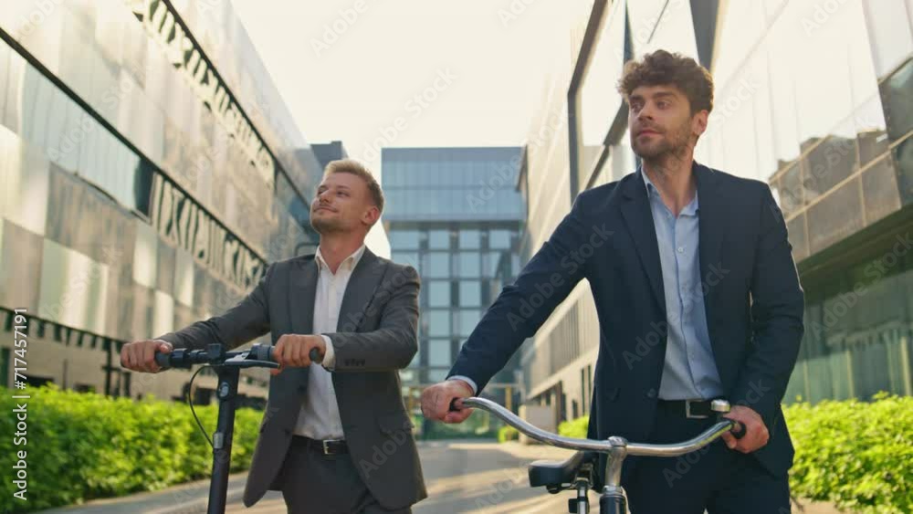Business managers holding scooter bicycle at downtown. Corporate people commute Business managers holding scooter bicycle at downtown. Corporate people commute