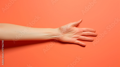 Outstretched hand against orange.